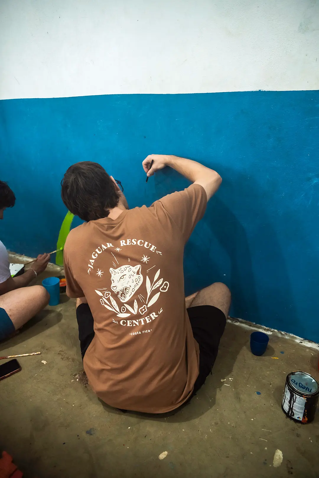 Voluntario pintando una pared de azul