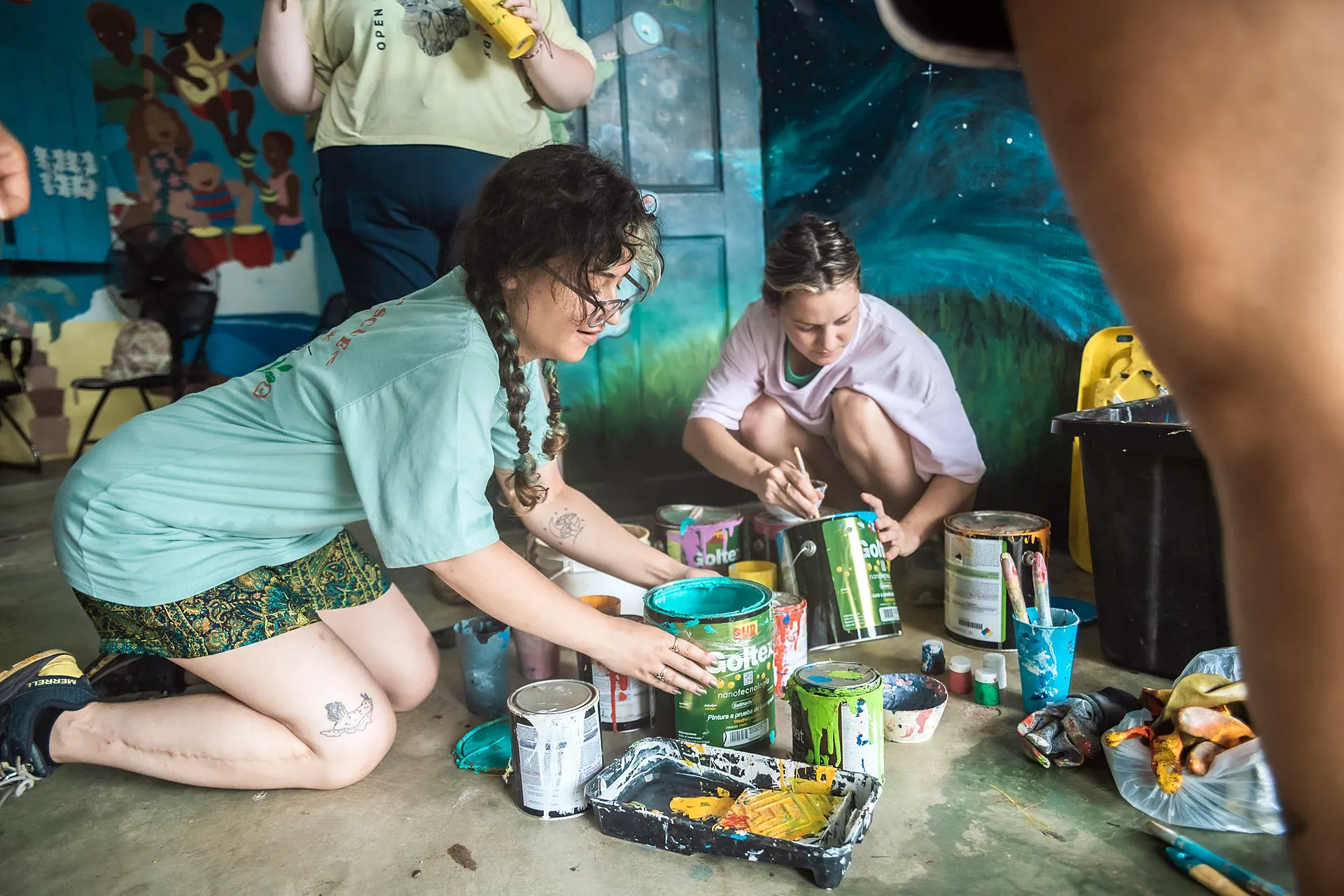 Voluntarias pintando latas en un taller comunitario